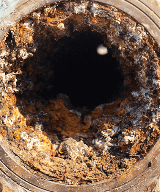 Detail of clogged debris and corrosionin an old chemical processing pipe.