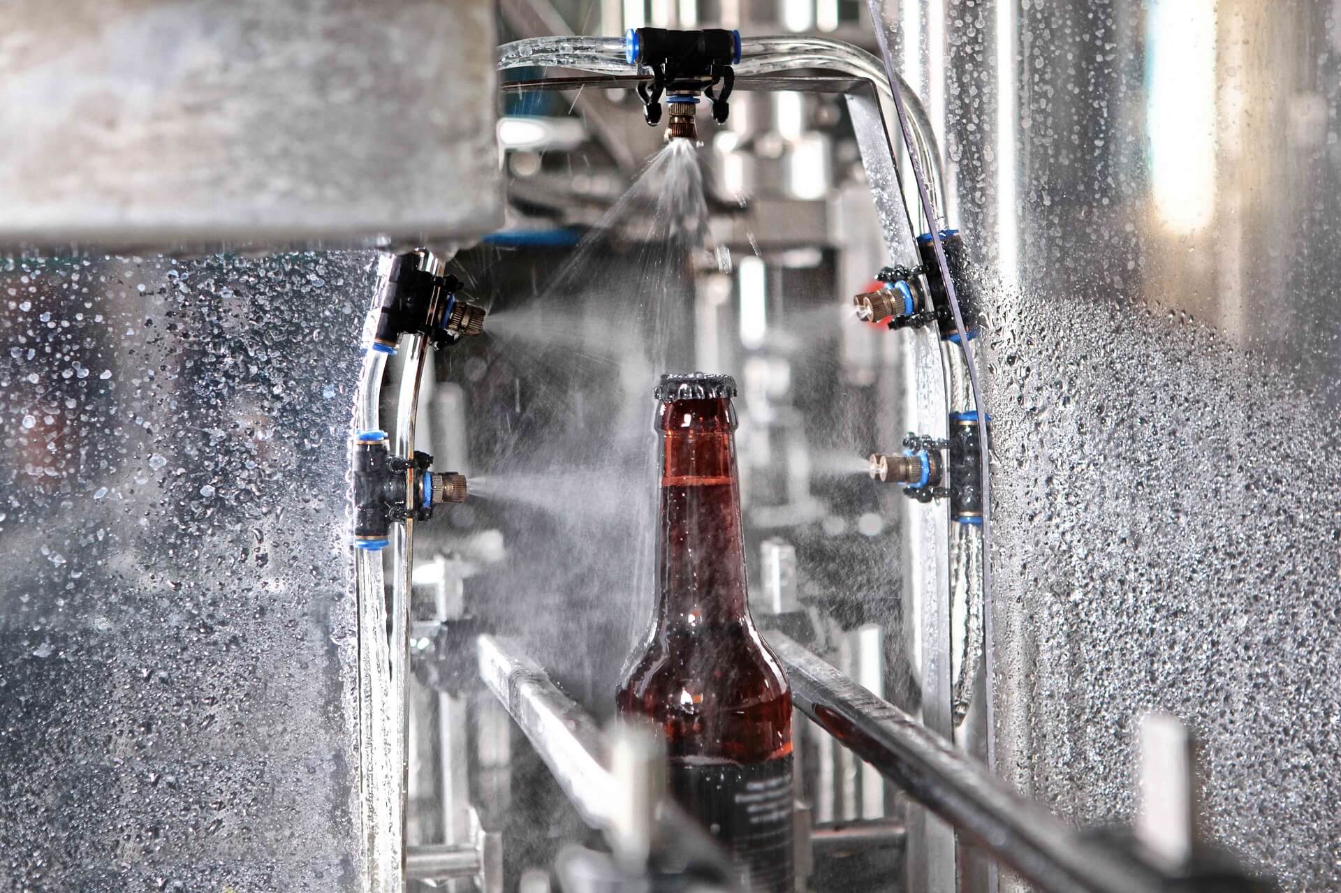 水流下传送带上的一瓶啤酒的细节。只有瓶子是焦点。生产的概念。gydF4y2Ba