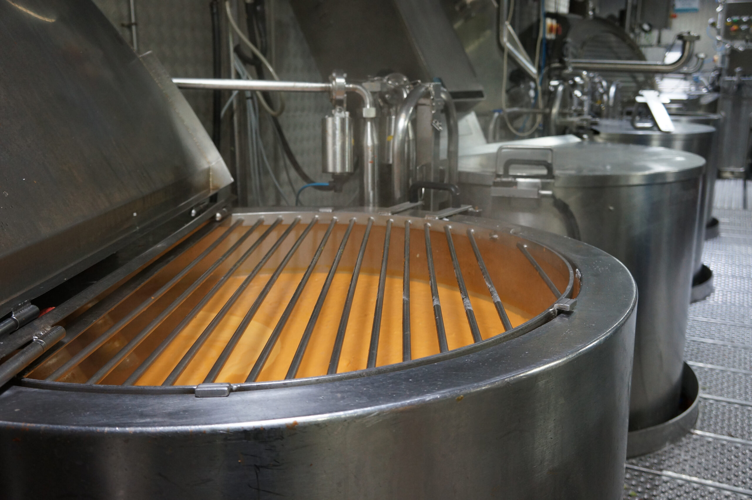Soup in a large metal container being cooked.