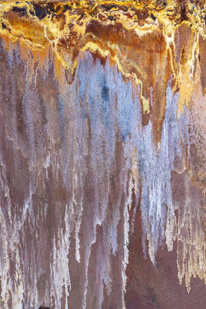 Detail of rust pattern on the side of a metal storage tank.