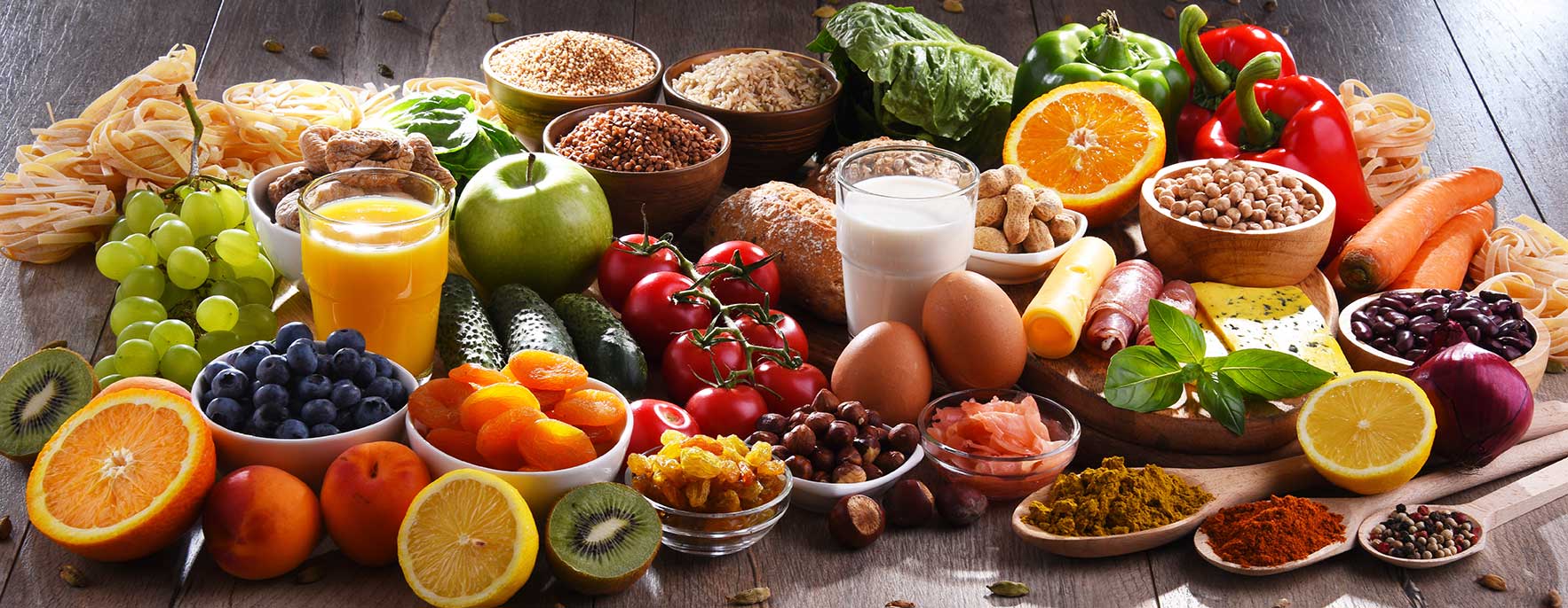A composition with assorted food and beverage products on wooden kitchen table