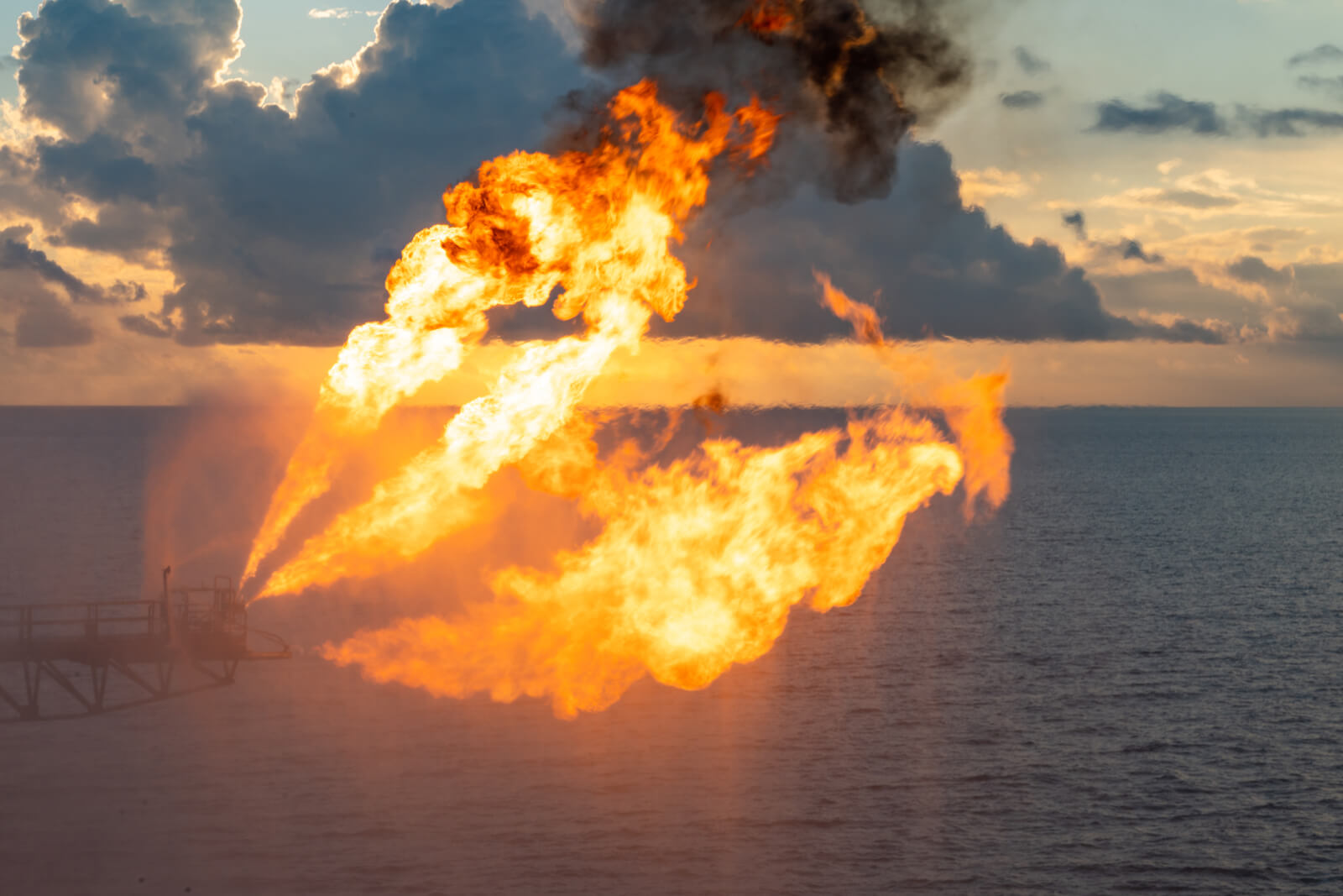 Well testing operation (flaring) of an oil and gas drilling rig. Burning huge gas flame controlled by a fire protection deluge system consisting of specialized spray nozzles.
